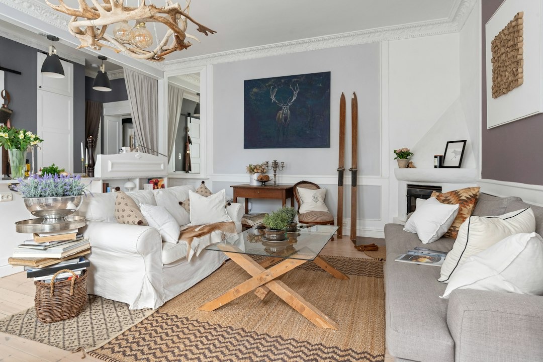 Living room with two sofas and a rustic antler chandelier.
